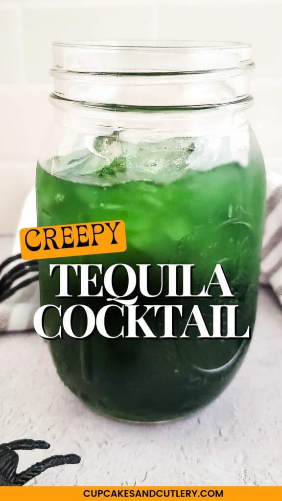 TEXT: Creepy Tequila Cocktail with a jar holding a dark green cocktail on a white table.