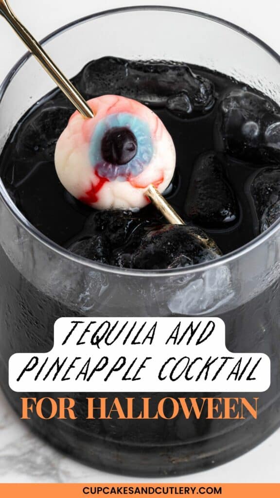 Text: Tequila and Pineapple Cocktail for Halloween with a close up of a black tequila cocktail with gummy eye garnish.