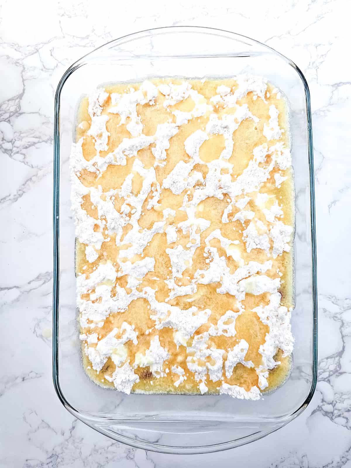 Yellow cake mix sprinkled over the top of the Strawberry cheesecake dump cake with melted butter poured over.